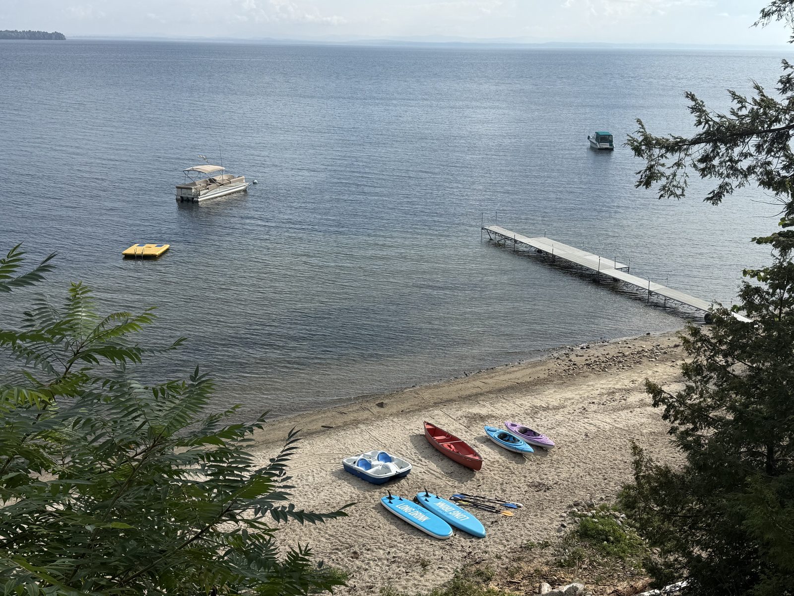The beach, dock, and fleet of kayaks and paddle boards